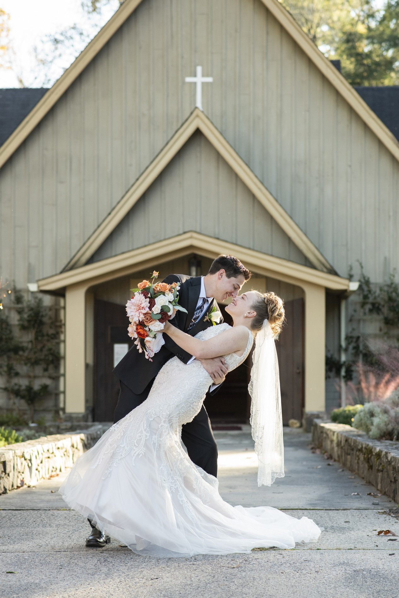 Couple dipping in front of Kanuga wedding chapel