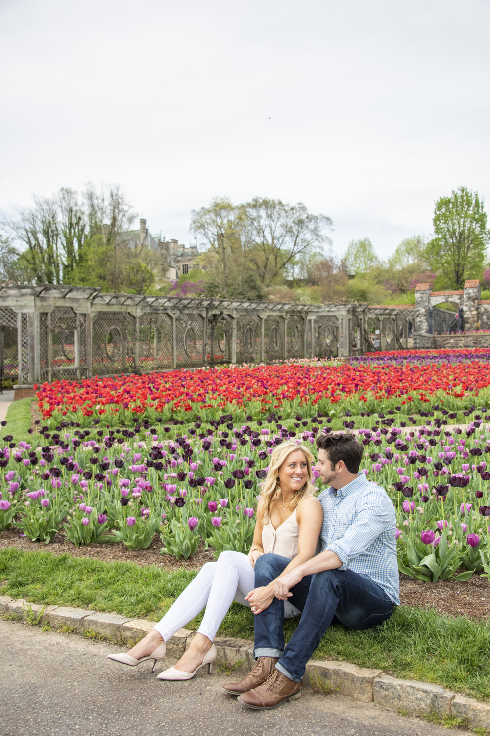 Couple sitting among tulips during Biltmore Engagement Photos