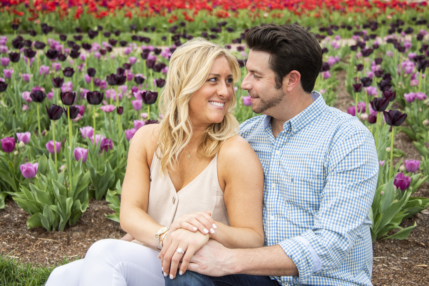 Couple sitting among tulips during Biltmore Engagement Photos