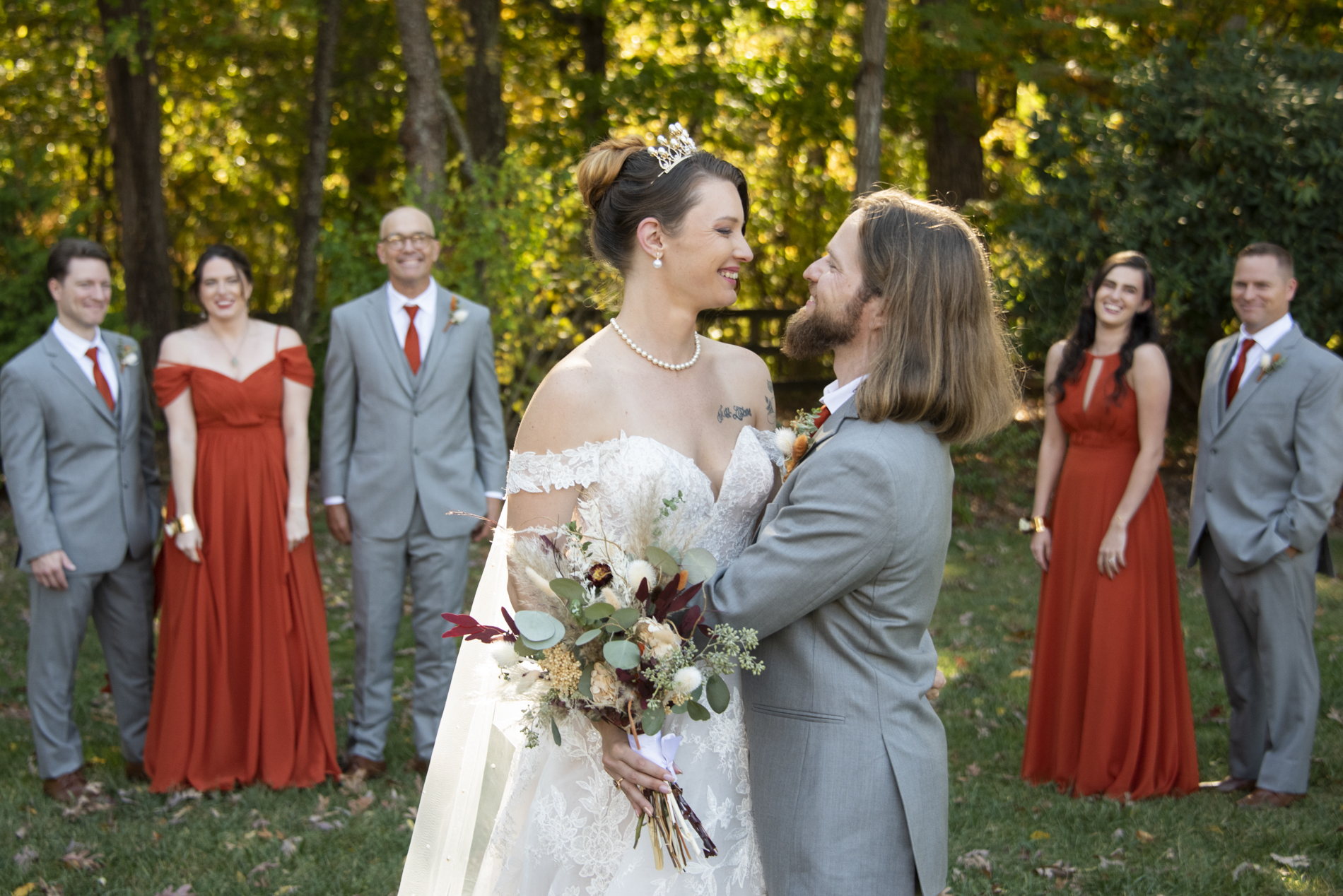 Couples smiling in front of wedding party