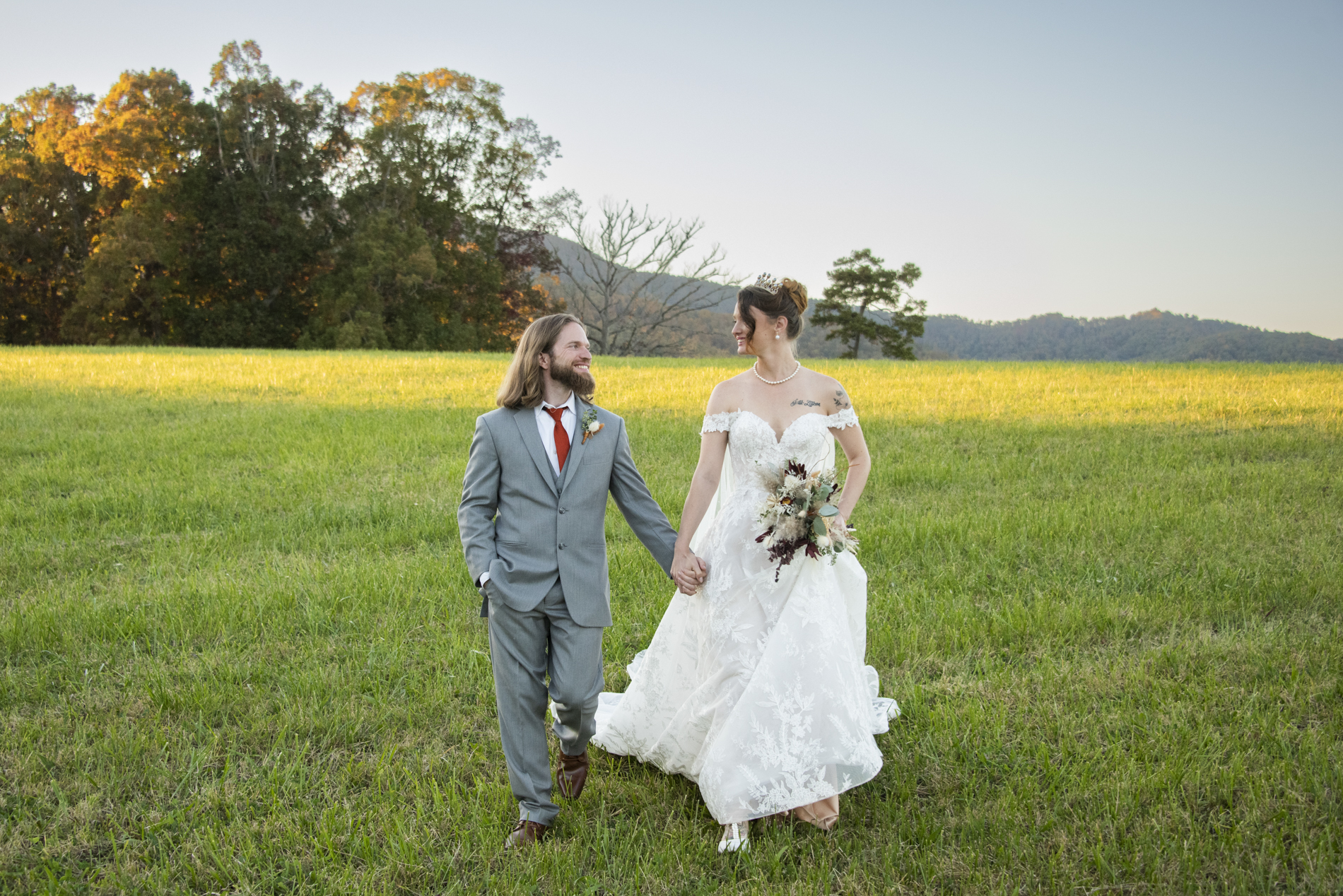 Couple walking in field at The Farm Wedding Venue