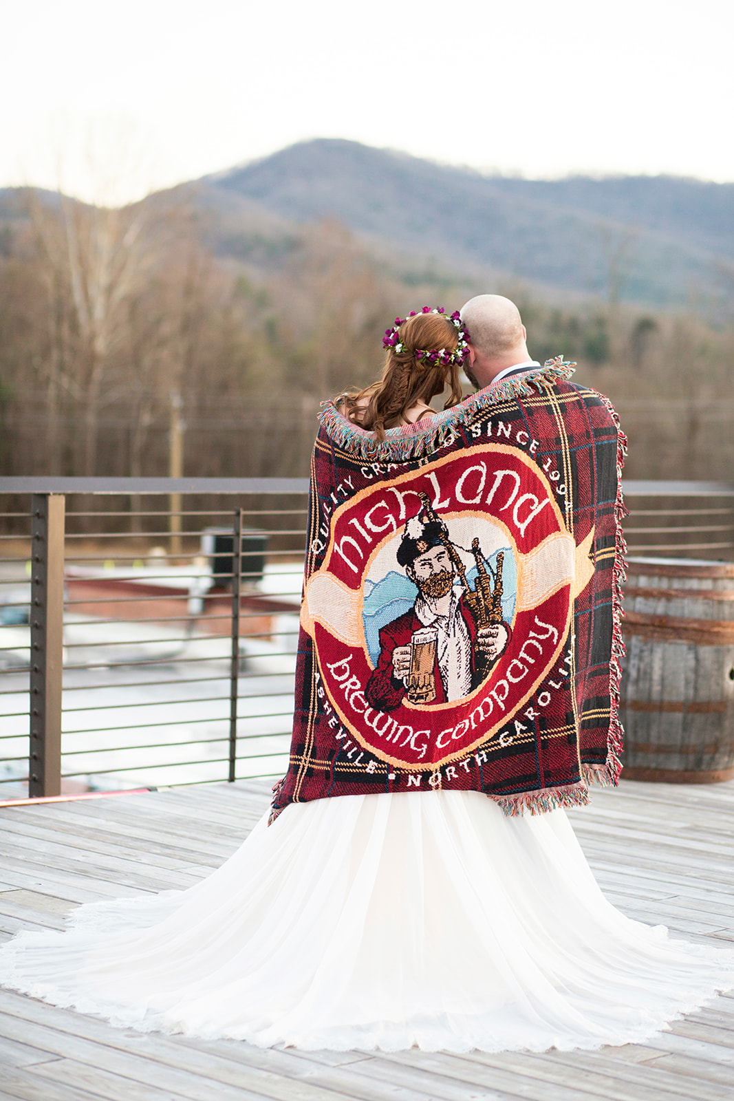 Couple snuggling under blanket looking at mountains during Highland Brewery Wedding