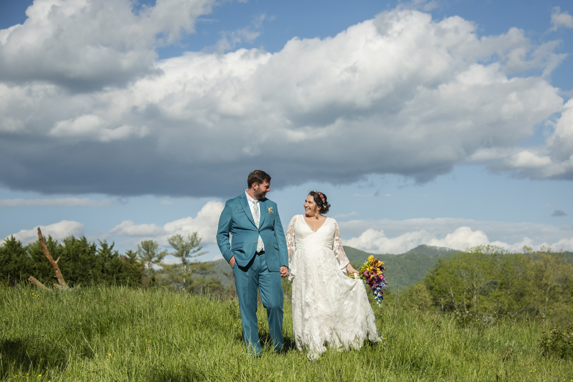 Couple walking in field with mountains