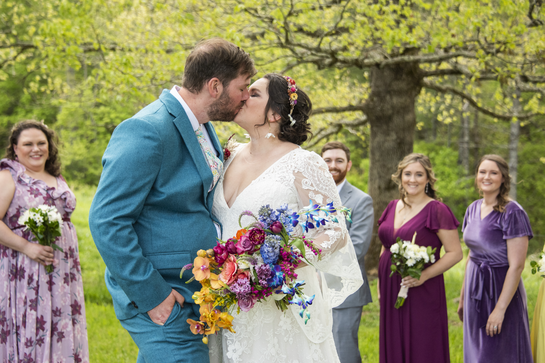 Couple kissing in front of wedding party at Emerald Ridge Farm