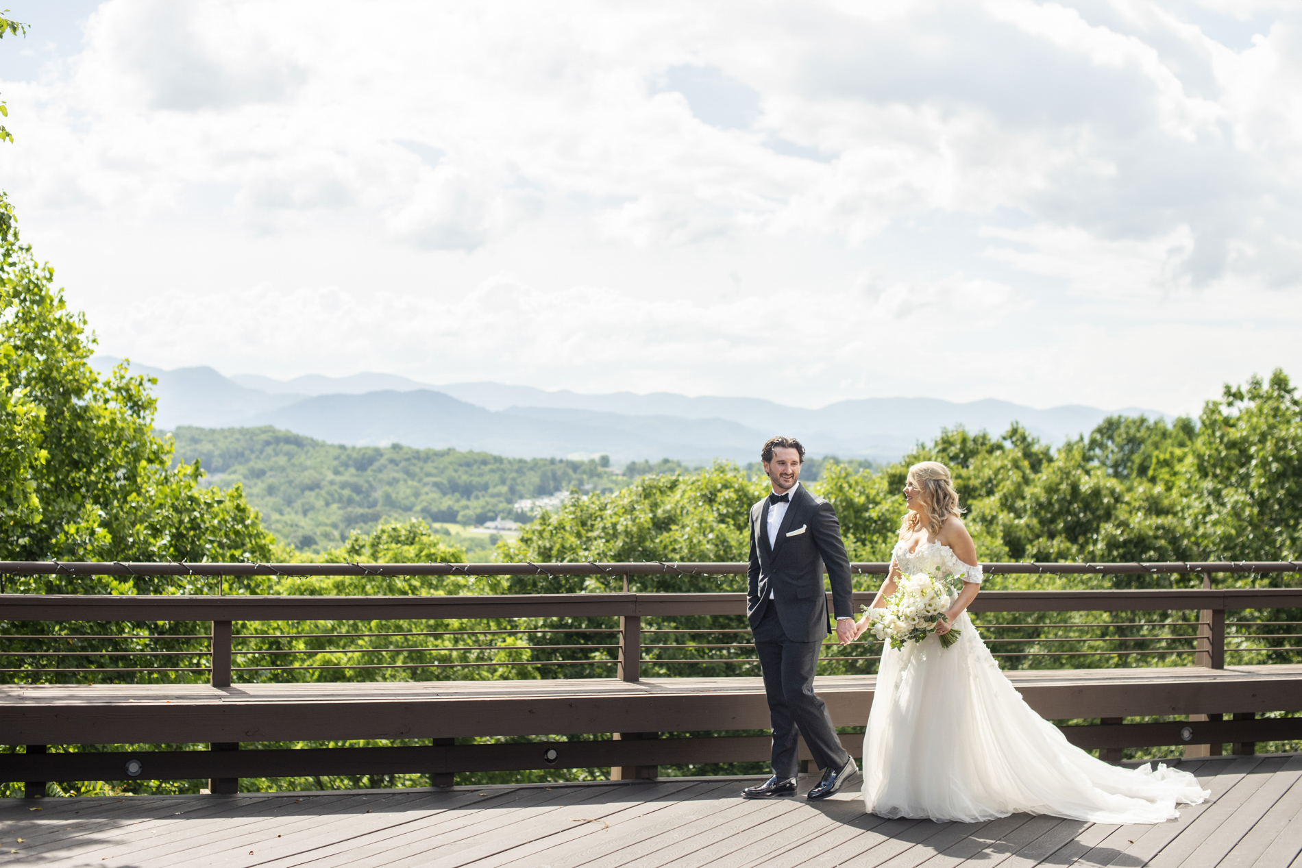 Couple walking at wedding with mountains behind at Crest Center and Pavilion