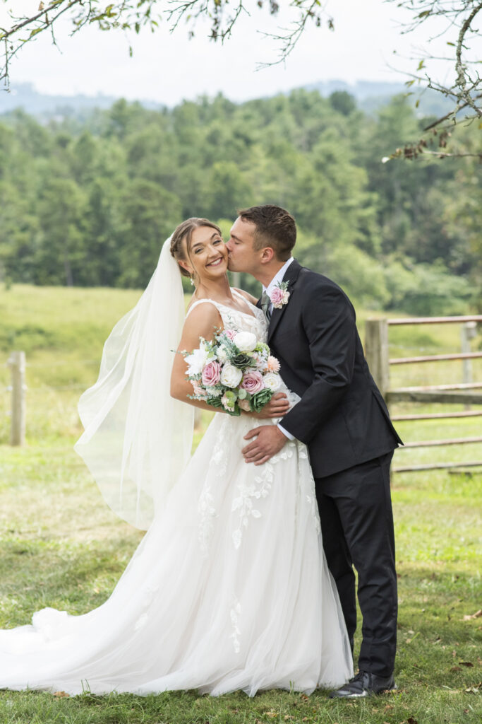 Groom kissing bride on cheek
