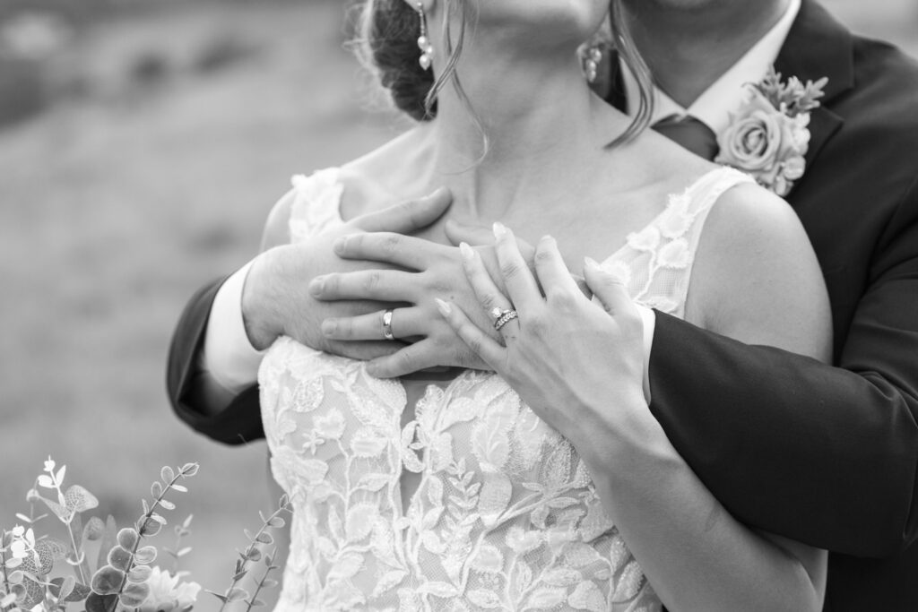 couple snuggling with rings showing