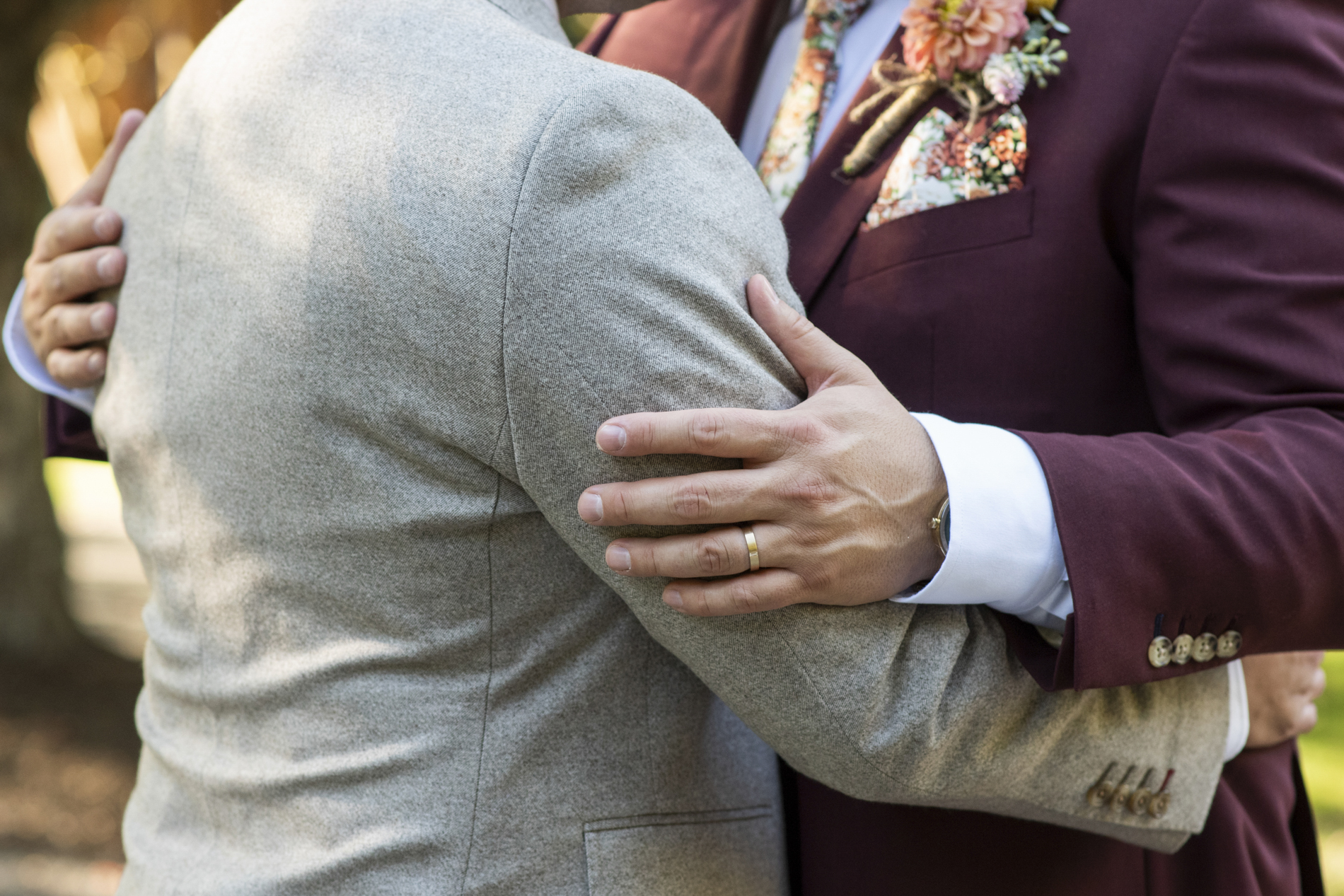 Couple snuggling at same sex wedding