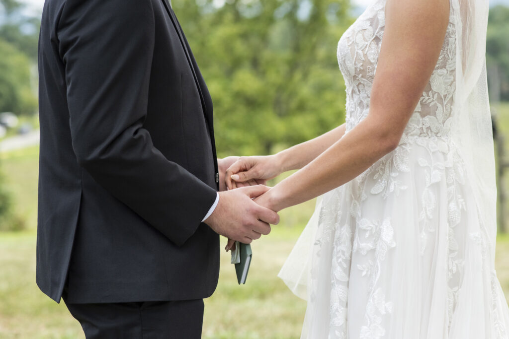couple holding hands during vow reading