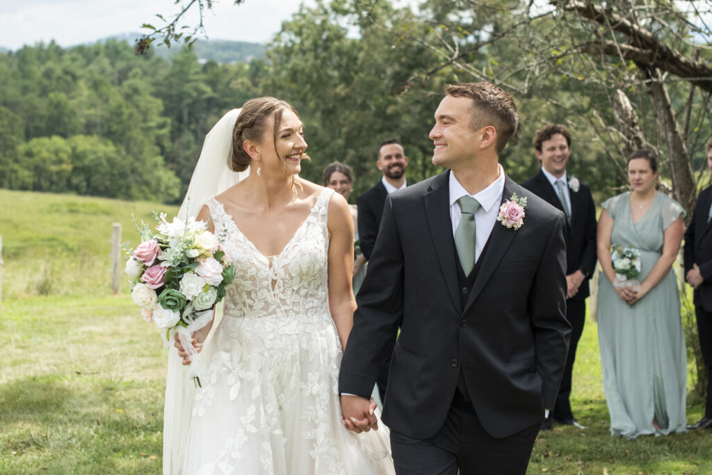 couple walking in front of wedding party