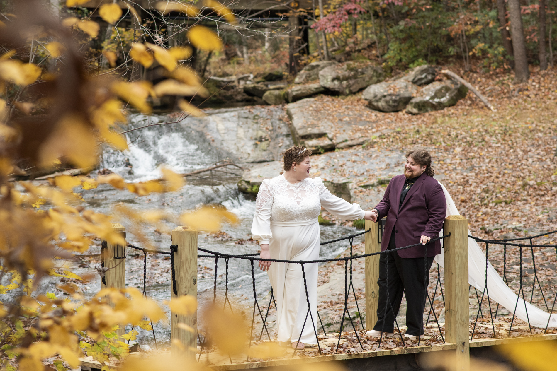 queer couple walking on bridge at lake lure elopement
