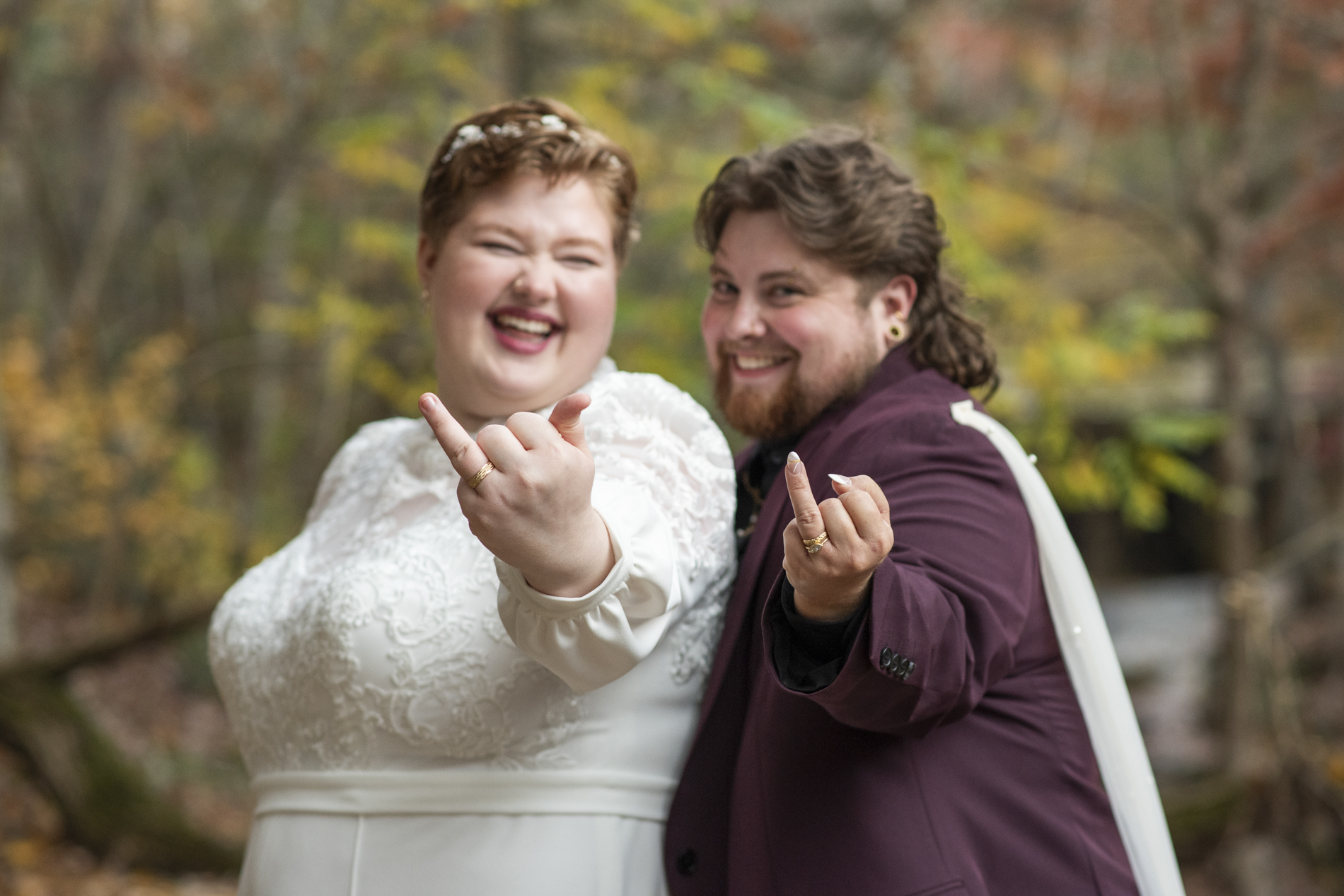 queer couple showing wedding rings at lake lure elopement