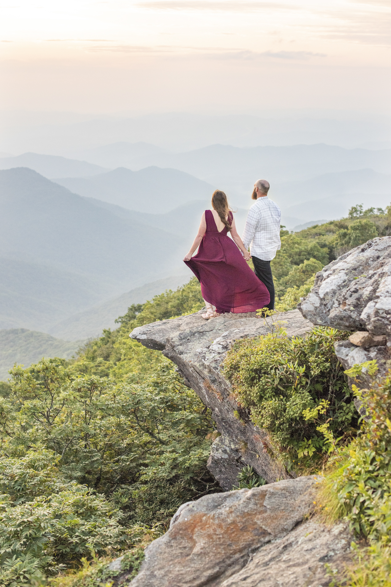 Engagement photos standing on rock outcropping at Craggy Pinnacle in best places to propose in NC