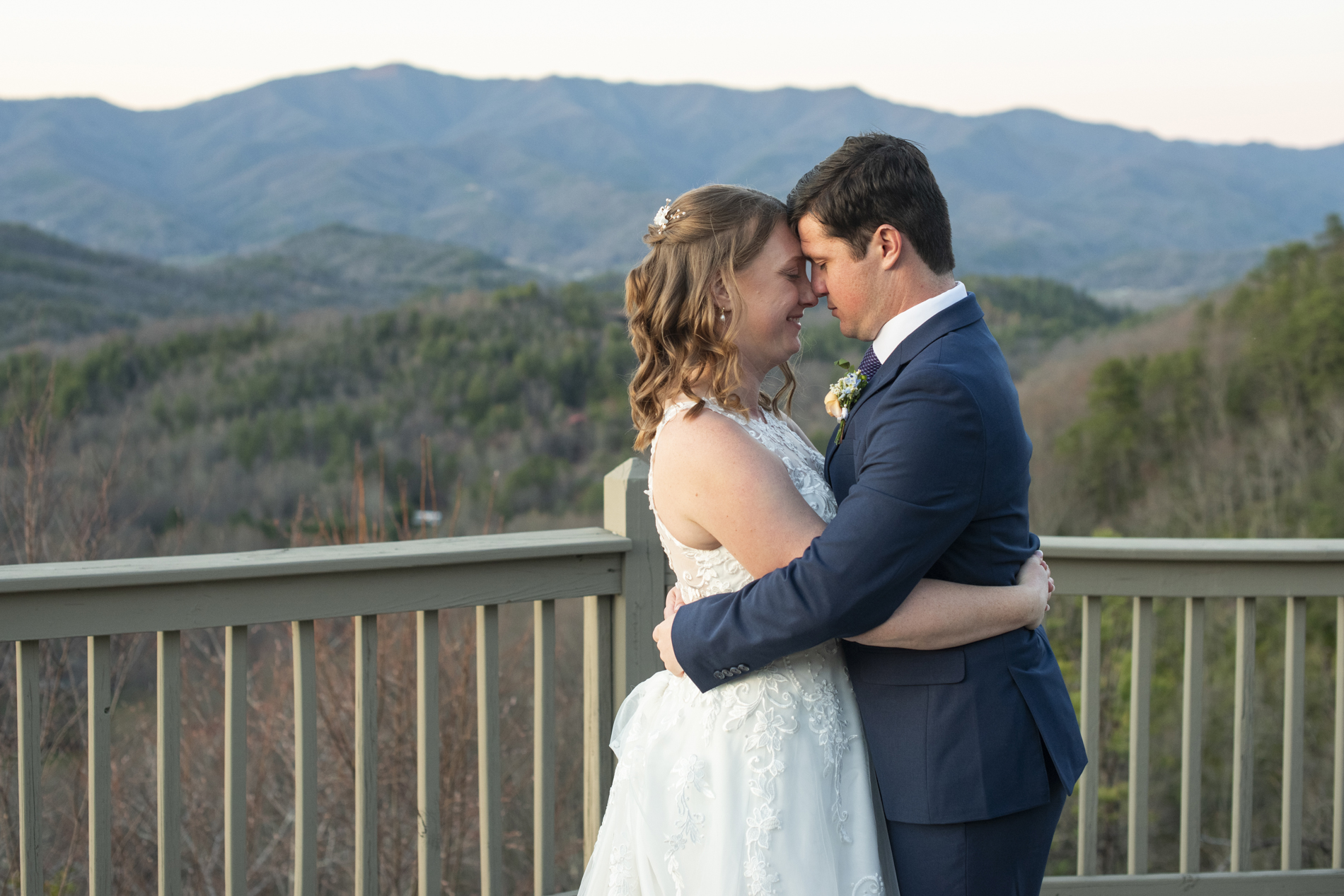 Bride and groom snuggling on mountain top at Hawkesdene wedding venue