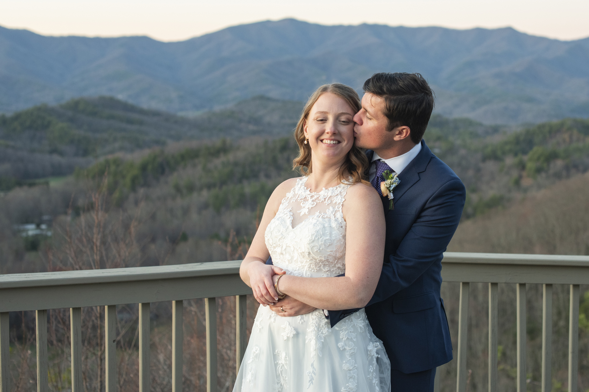 Bride and groom snuggling on mountain top at Hawkesdene wedding venue