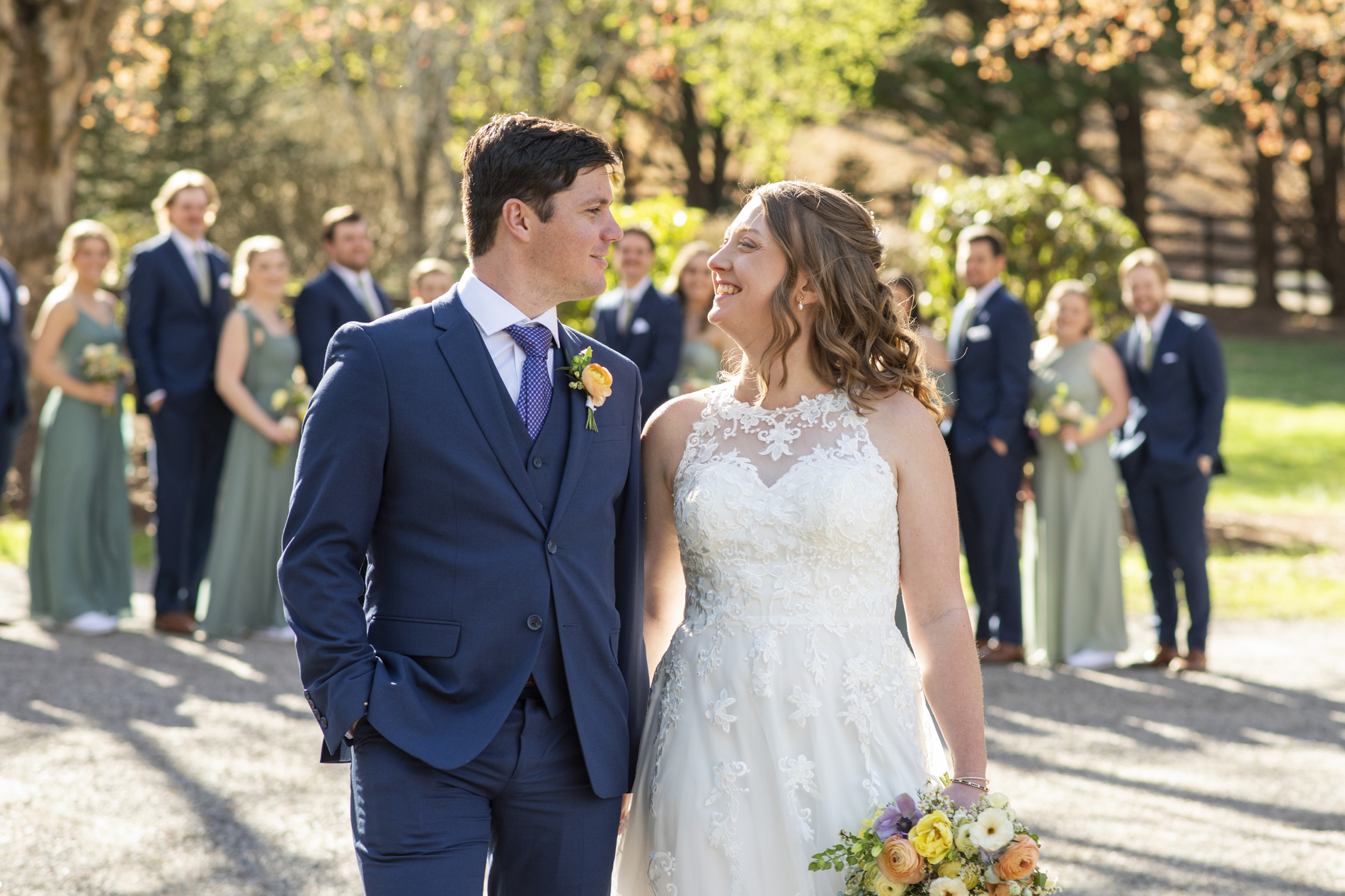 Couple walking with spring flowers behind at Hawkesdene wedding venue