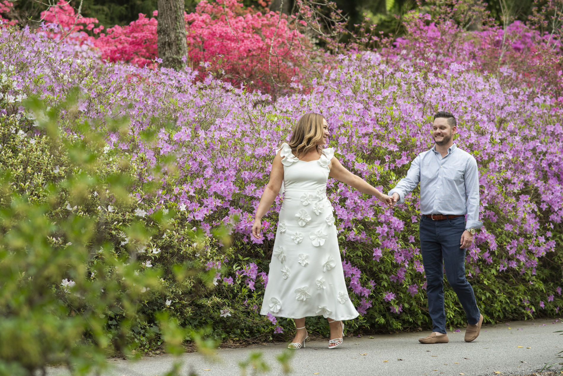 Couple holding hands and walking through Biltmore Azalea Garden in Asheville, NC