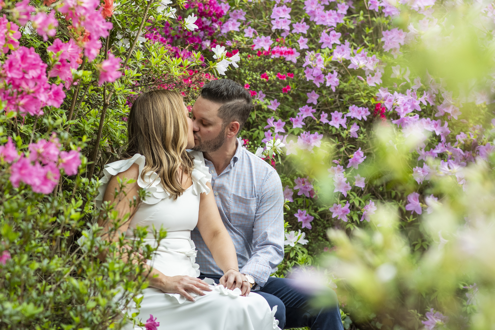Couple kissing on bench in Biltmore Azalea Garden in Asheville, NC