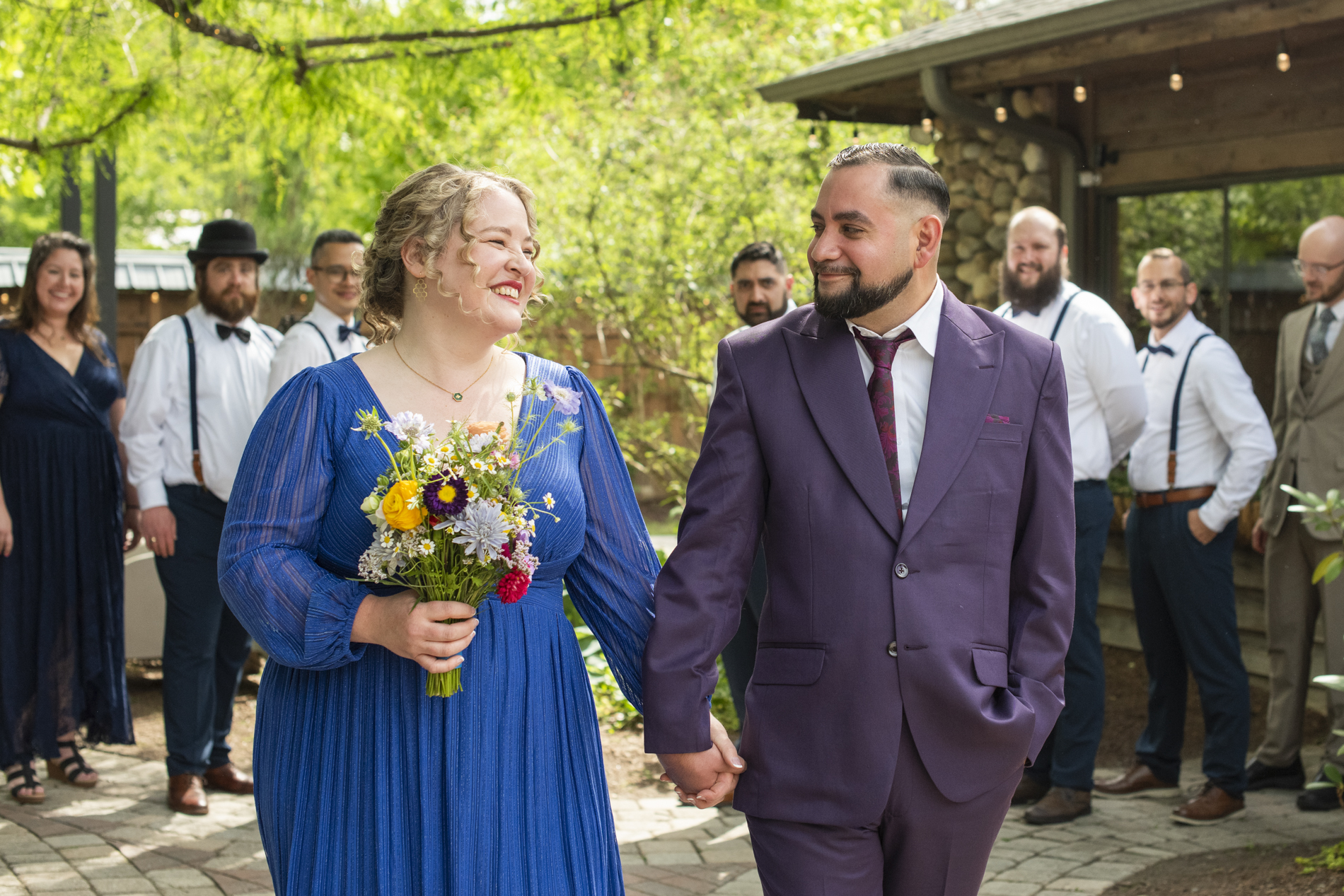 Bride and groom walking with wedding party behind them