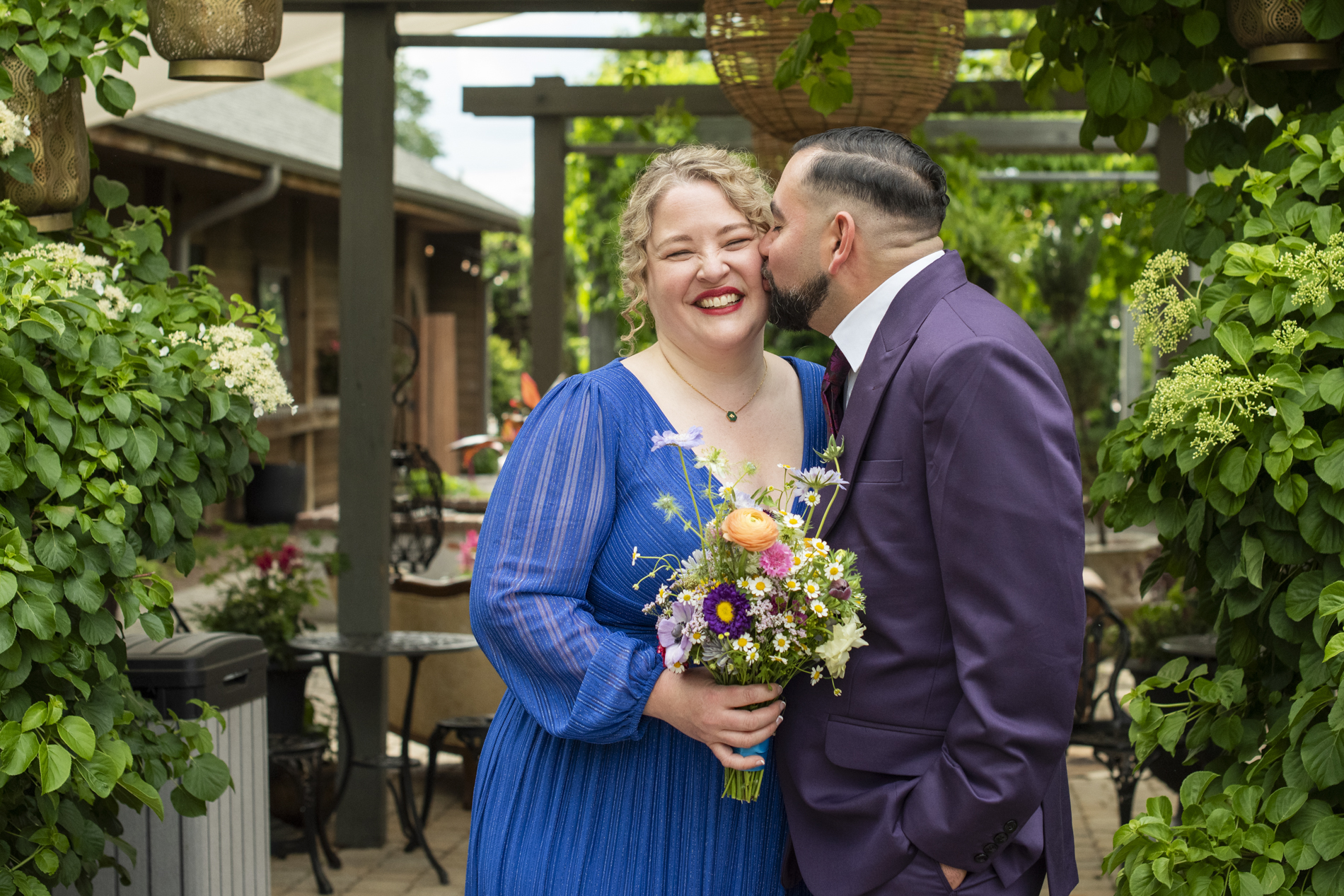 Groom kissing bride on cheek at Haiku Asheville