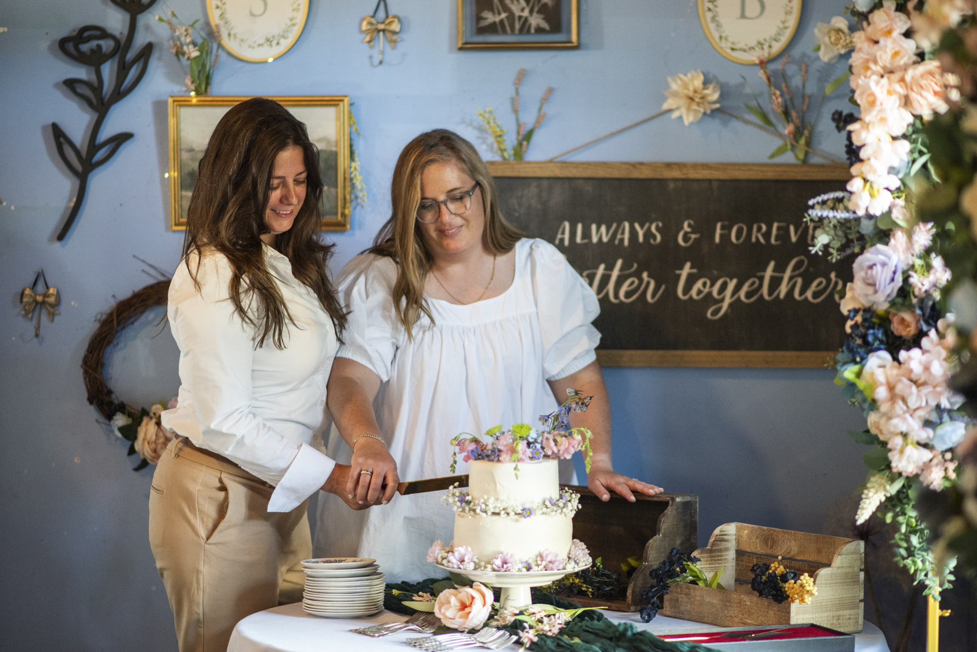Brides cutting cake at LGBTQ wedding reception at Birdfoot