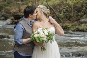 lgbtq couple kissing in creek at Asheville Botanical Gardens
