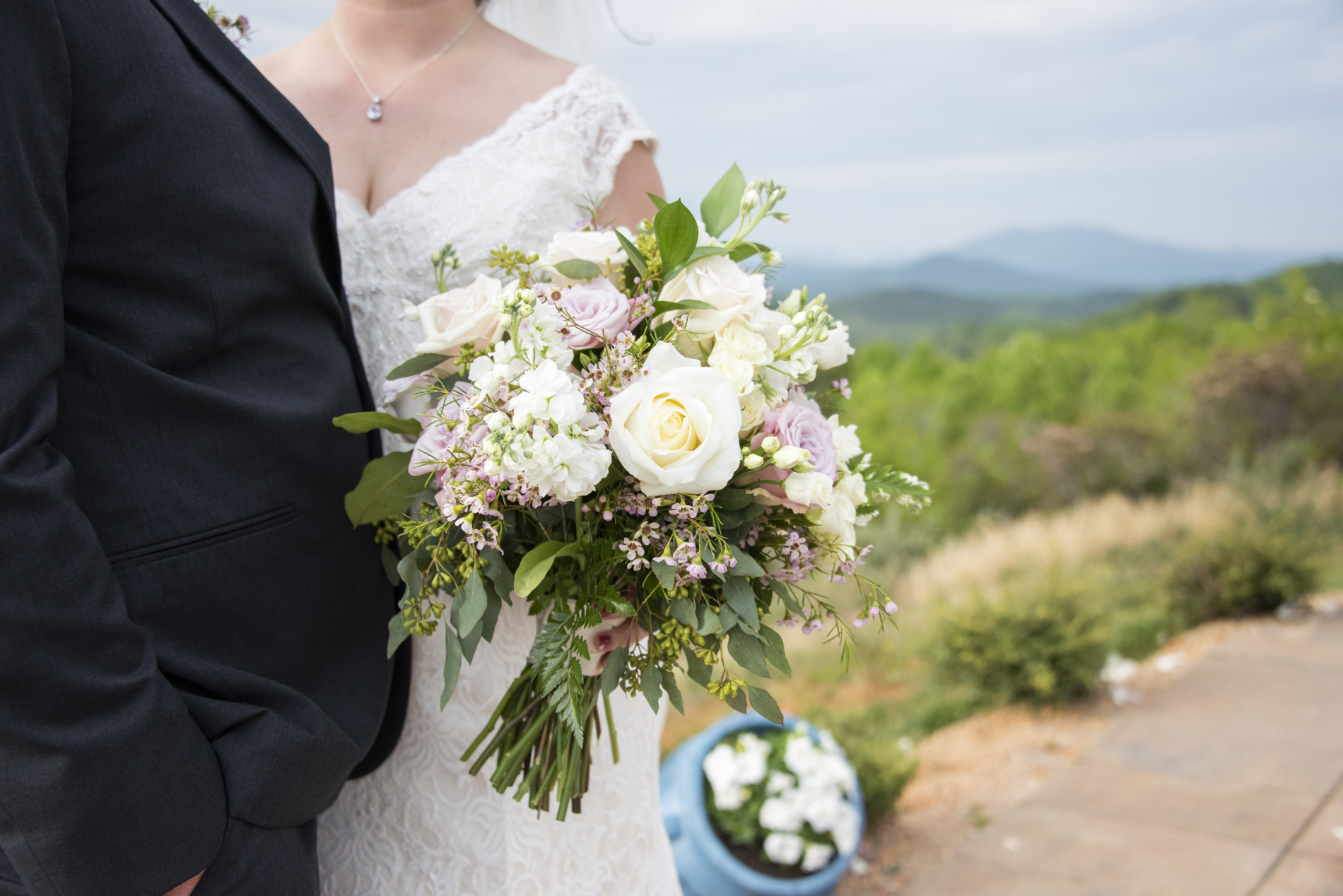 couple holding bouquet with mountains behind