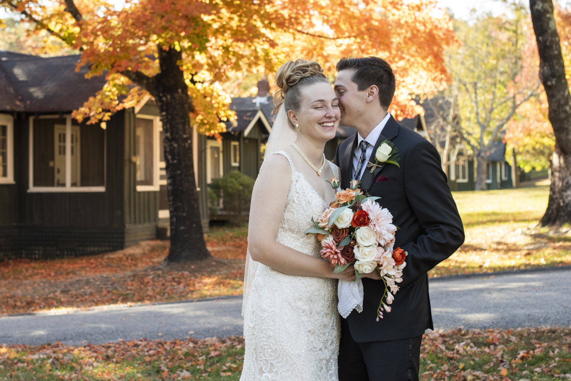couple snuggling at fall wedding at Kanuga near Asheville