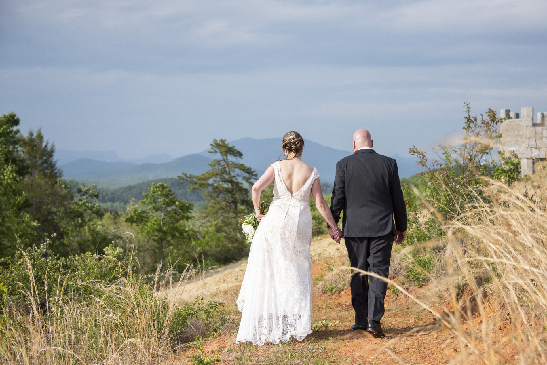 couple walking toward mountains at something blue mountain venue