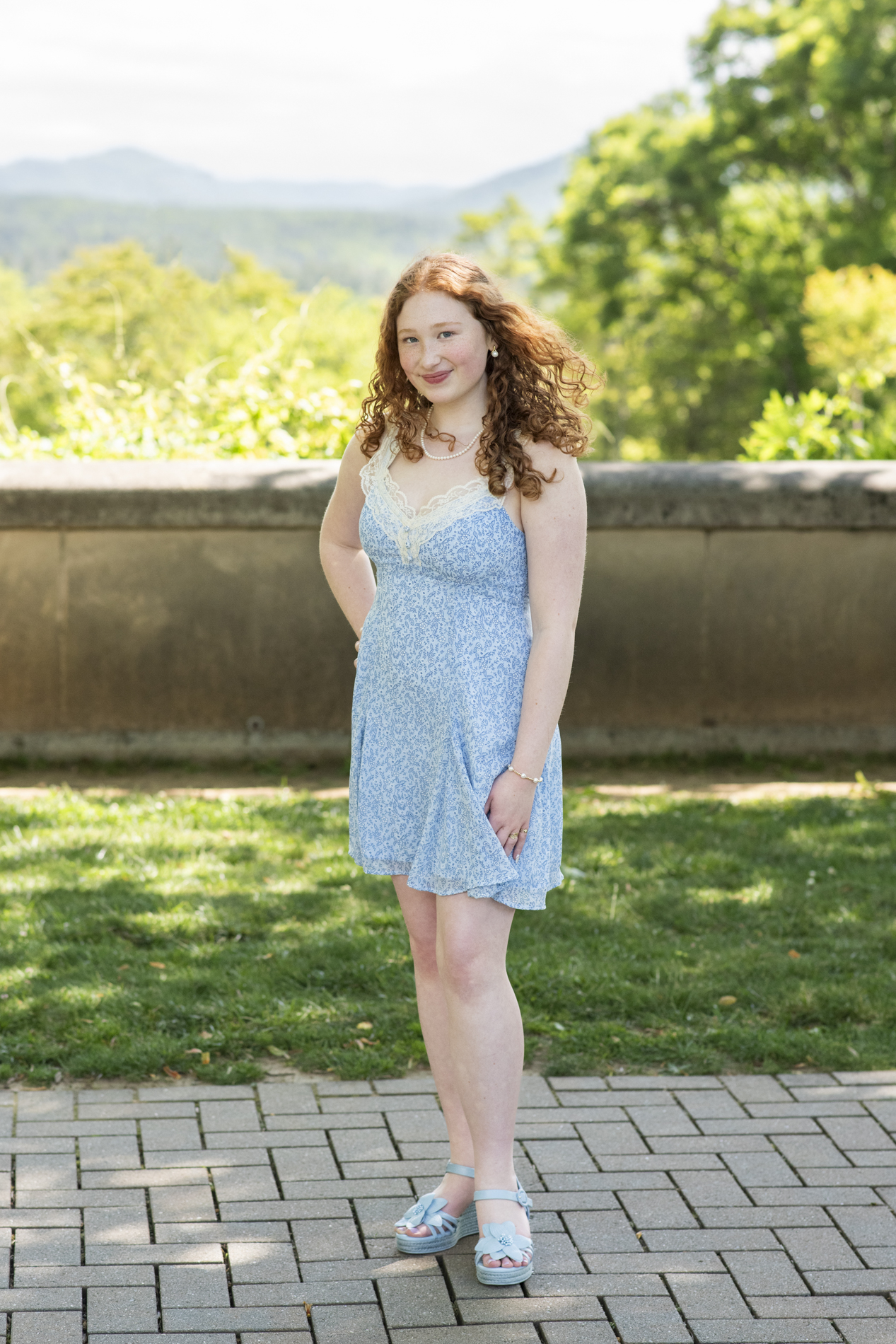 graduating senior at biltmore estate with mountains behind