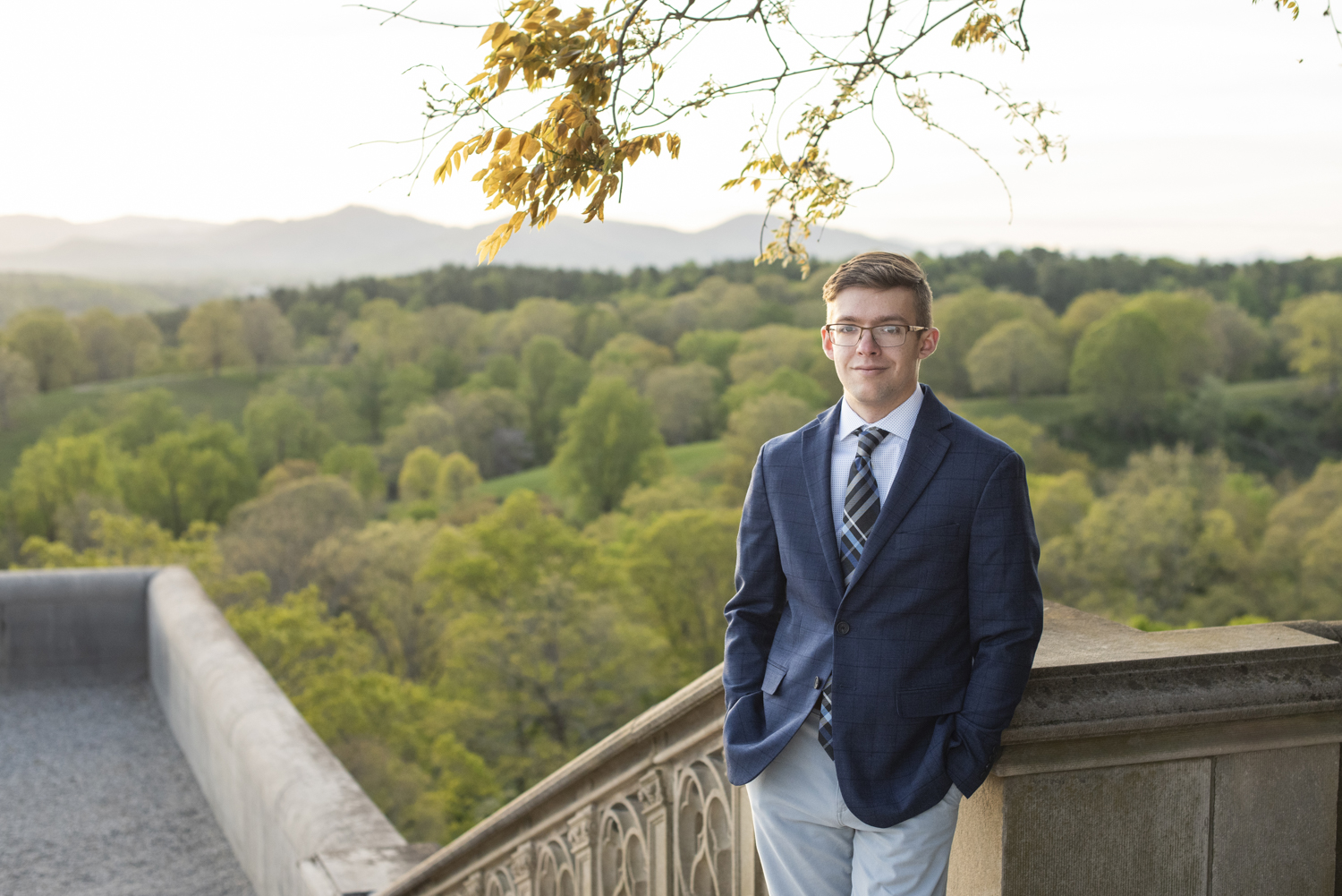 graduating senior at biltmore estate with mountains behind